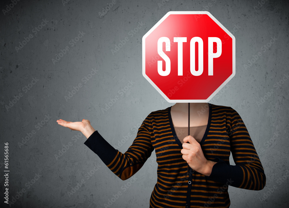 Young woman holding a stop sign Young woman holding a stop sign