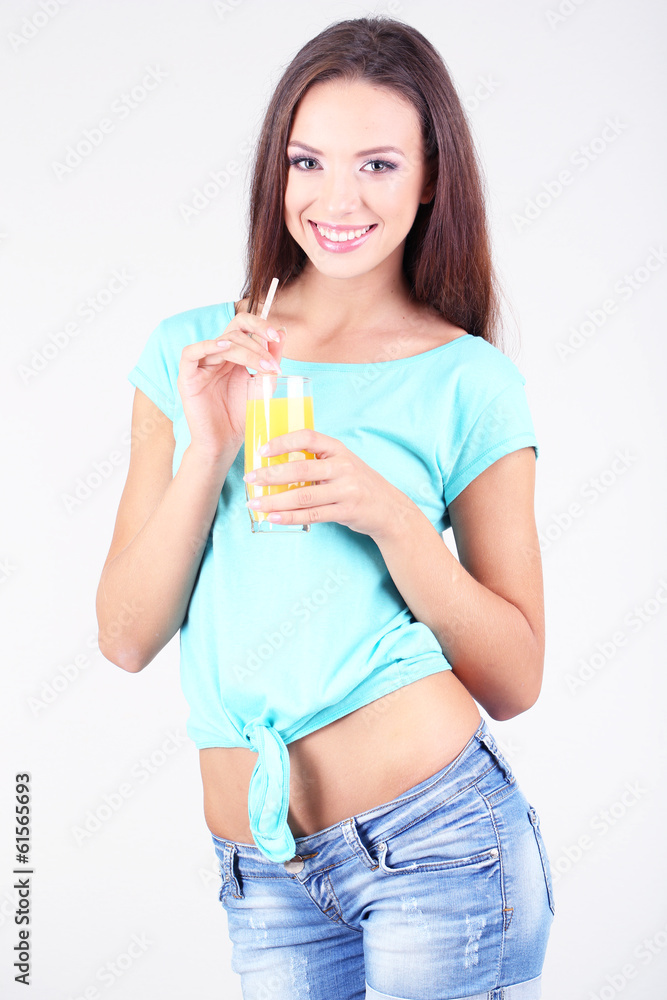 Beautiful girl with fresh juice on grey background Beautiful girl with fresh juice on grey background