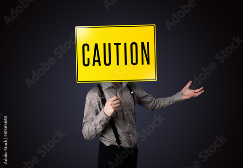 Businessman holding a caution sign