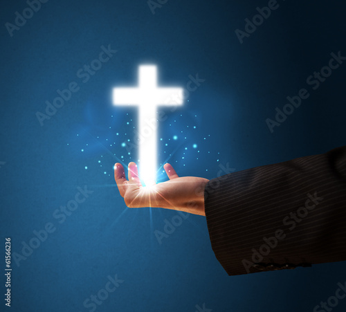 Glowing cross in the hand of a businessman