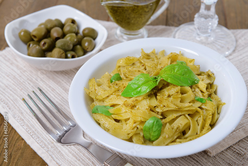 Delicious pasta with pesto on plate on table close-up