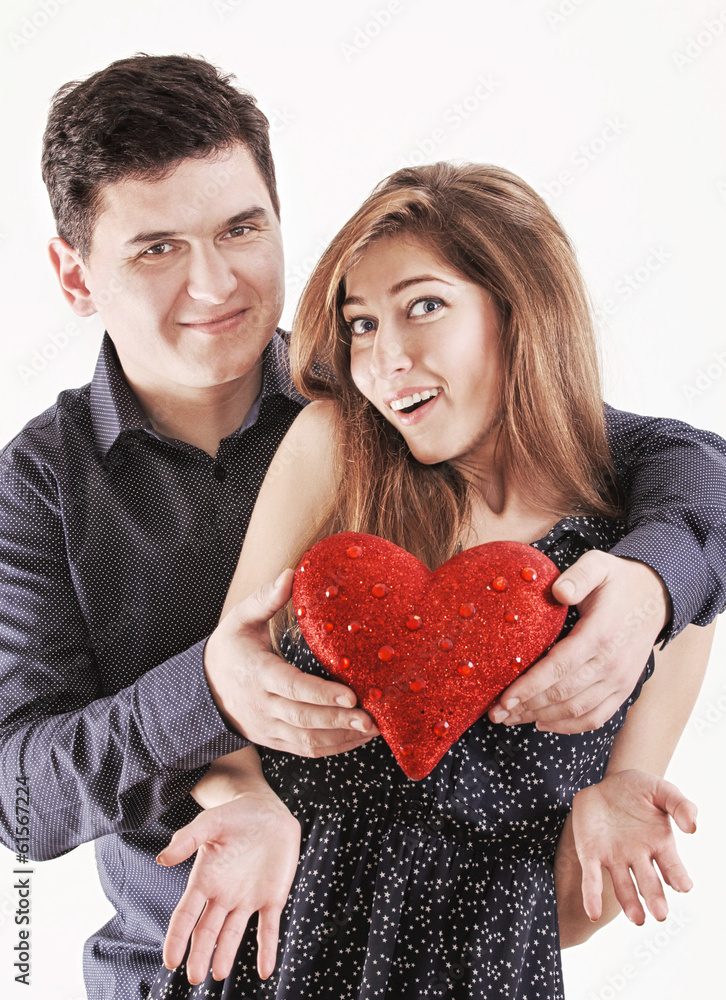 Happy young funny couple with red heart