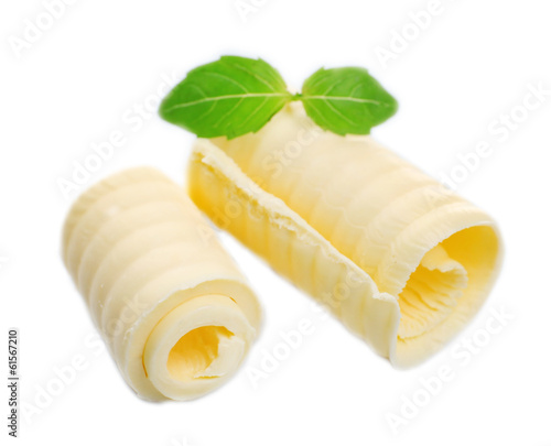 Curls of fresh butter with basil, isolated on white