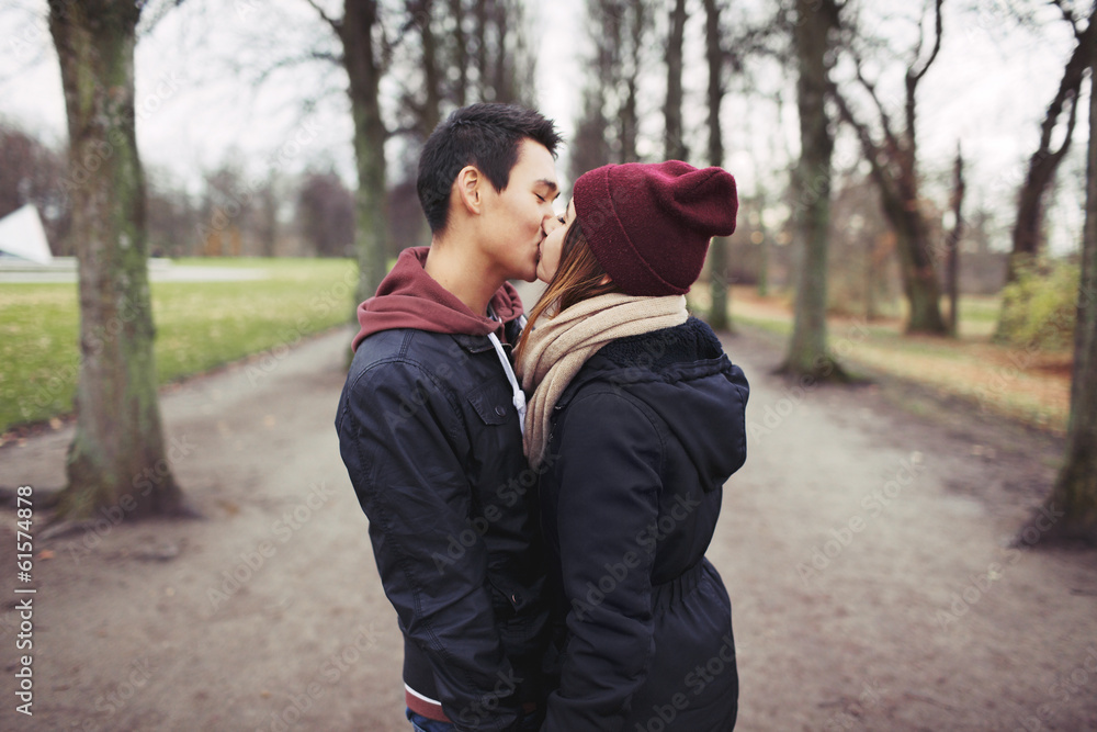 Teenage couple kissing outdoor in the park Teenage couple kissing outdoor in the park