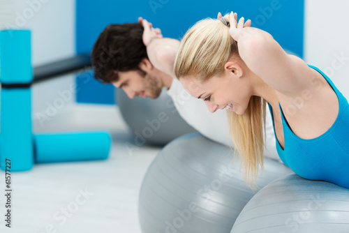 paar im fitness-studio trainiert rückenmuskulatur