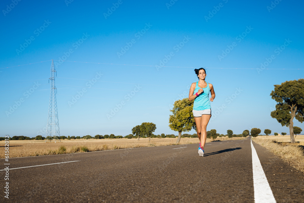 Fitness sporty woman running on road