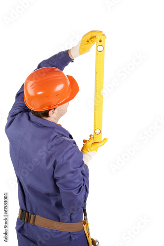 Worker in hard hat raising ruler.