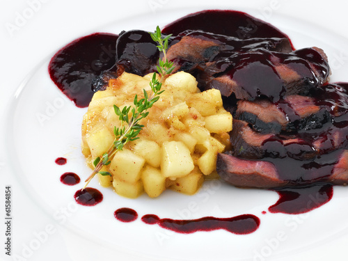 Delicious roasted sliced duck breast meat under wine and berry s