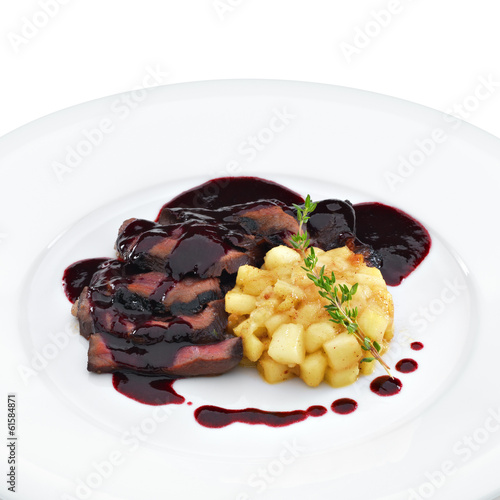 Delicious roasted sliced duck breast meat under wine and berry s