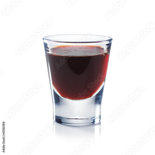 Red berries liqueur is the shot glass isolated on white. Bar and