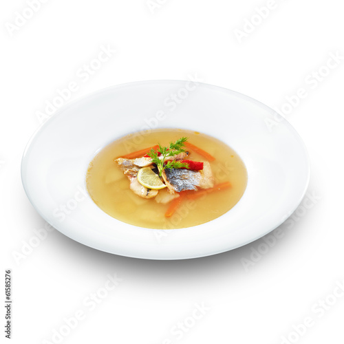 Hot tasty healthy soup with fish and vegetables served on a whit