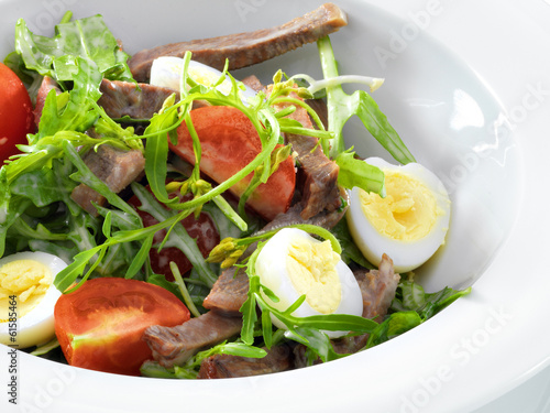 Warm delicious italian salad with beef tongue and arugula on a w