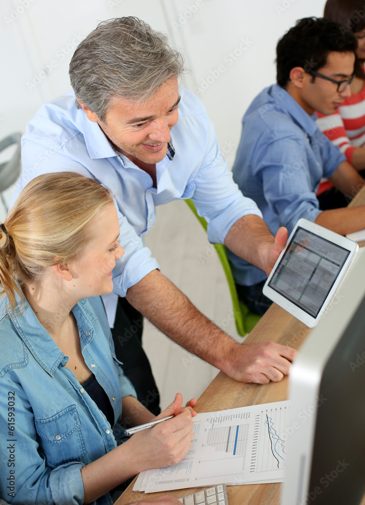 Obraz premium Teacher using digital tablet in school class