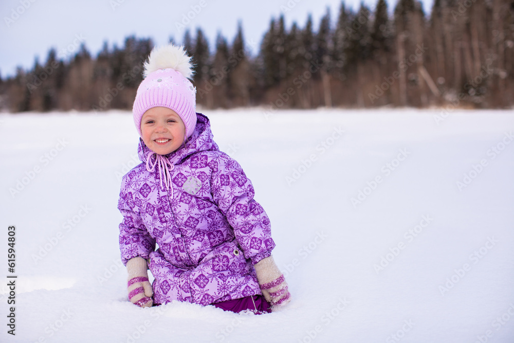 Little happy adorable girl having fun on the snow at winter