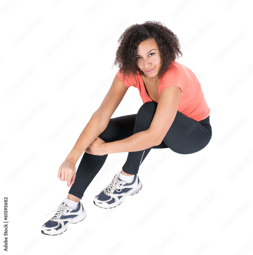 Junge Sportlerin sitzt auf dem Boden Junge Sportlerin sitzt auf dem Boden