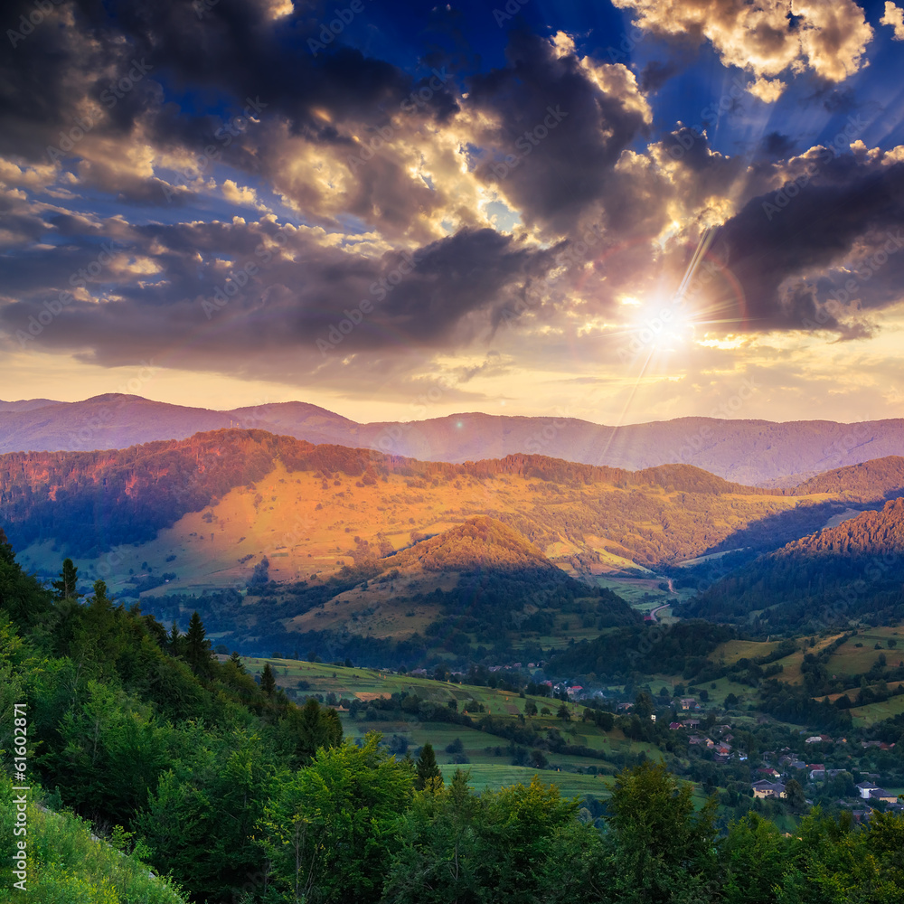 village on hillside meadow with forest in mountain at sunset village on hillside meadow with forest in mountain at sunset