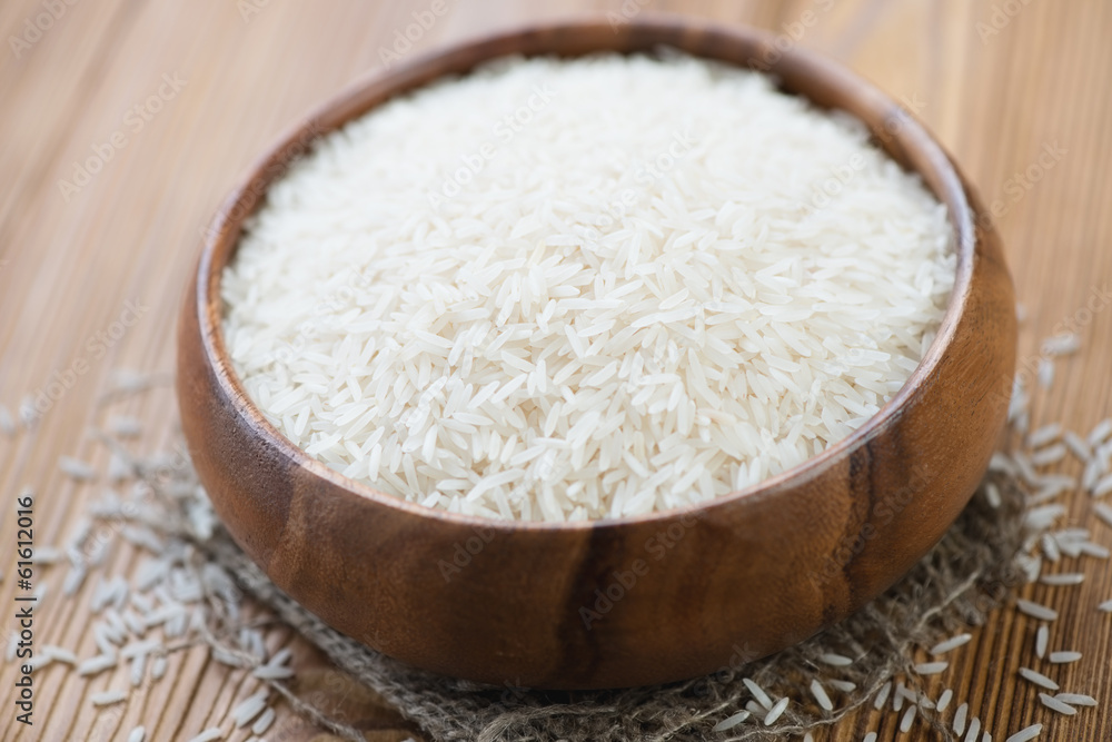 Wooden bowl with raw basmati kernels, close-up Wooden bowl with raw basmati kernels, close-up