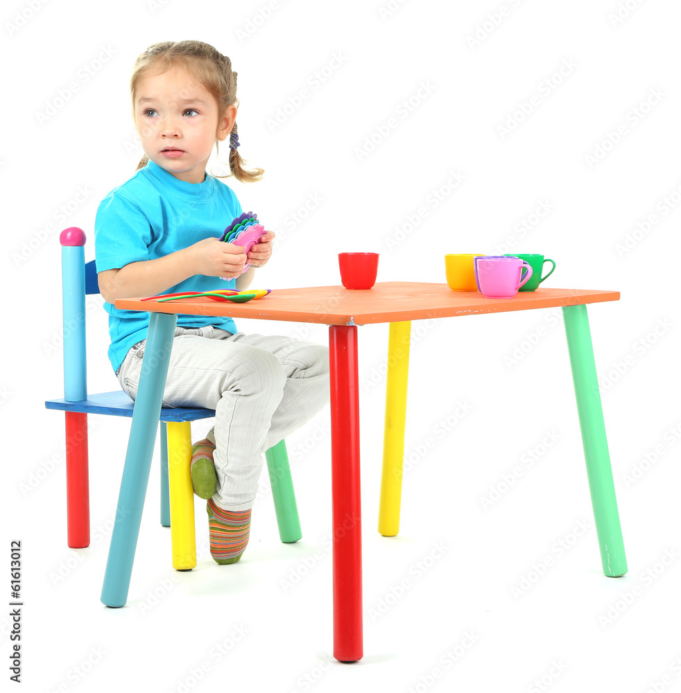 Little girl playing with colorful tableware isolated on white Little girl playing with colorful tableware isolated on white
