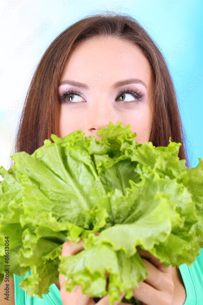 Beautiful girl with fresh salad on blue background Beautiful girl with fresh salad on blue background