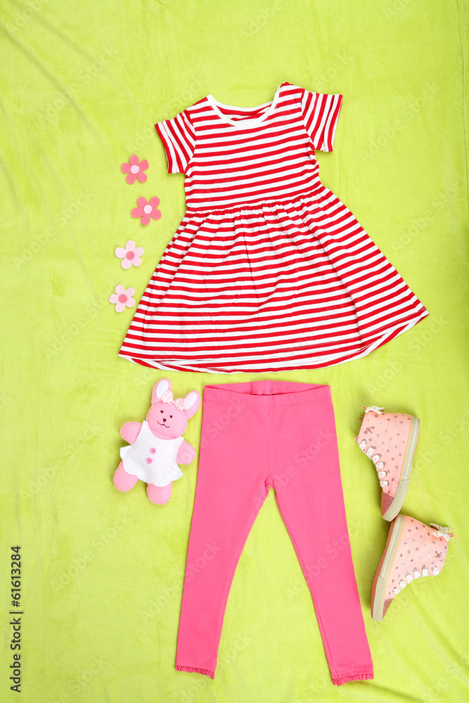 Beautiful clothes for little girl on green background Beautiful clothes for little girl on green background