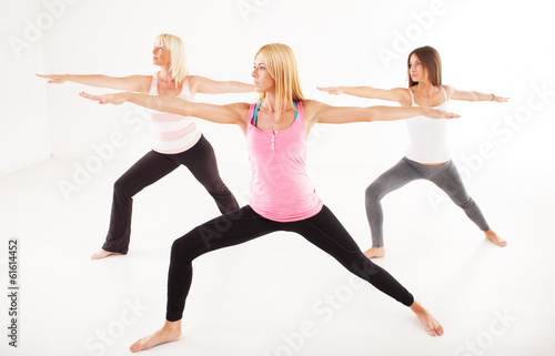Three beautiful women doing Yoga Warrior II Pose.