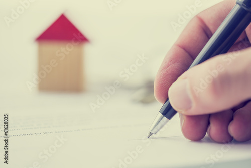 Εκτύπωση καμβά Man signing a deed of sale on a house