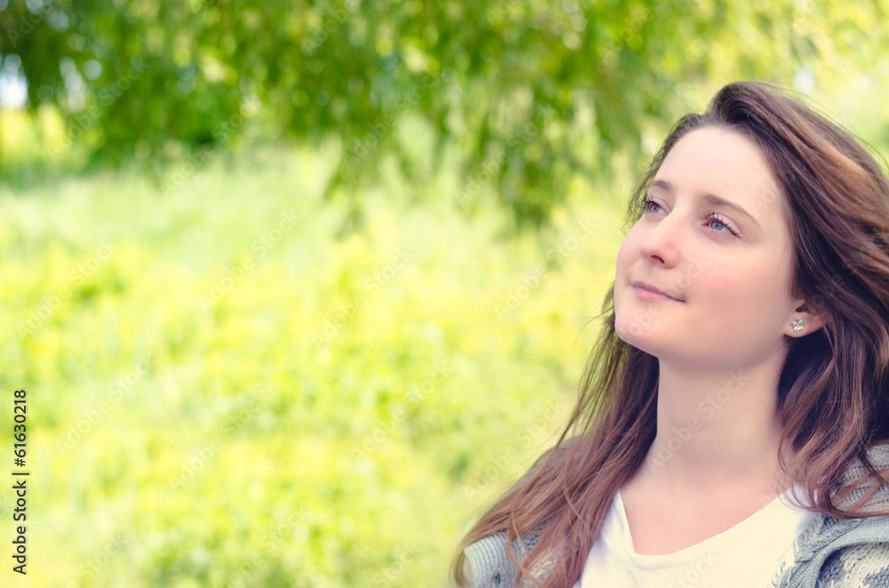 Beautiful young woman daydreaming in a park Beautiful young woman daydreaming in a park
