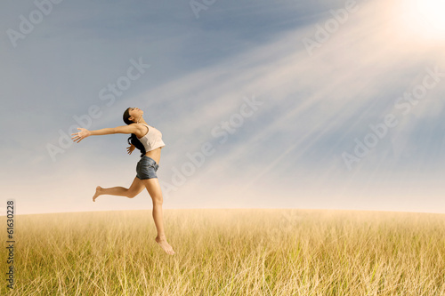 Girl jumping in golden wheat