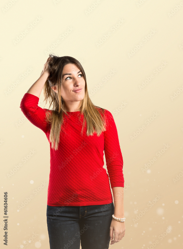 Young girl thinking over ocher background Young girl thinking over ocher background