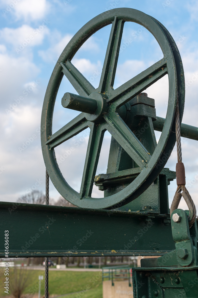 Historic cast iron lifting wheel against the blue sky