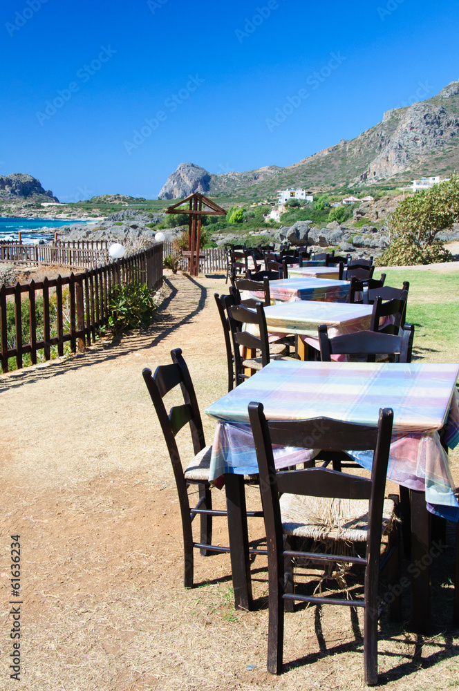 Table and chairs of a Greek taverna on the sea coast