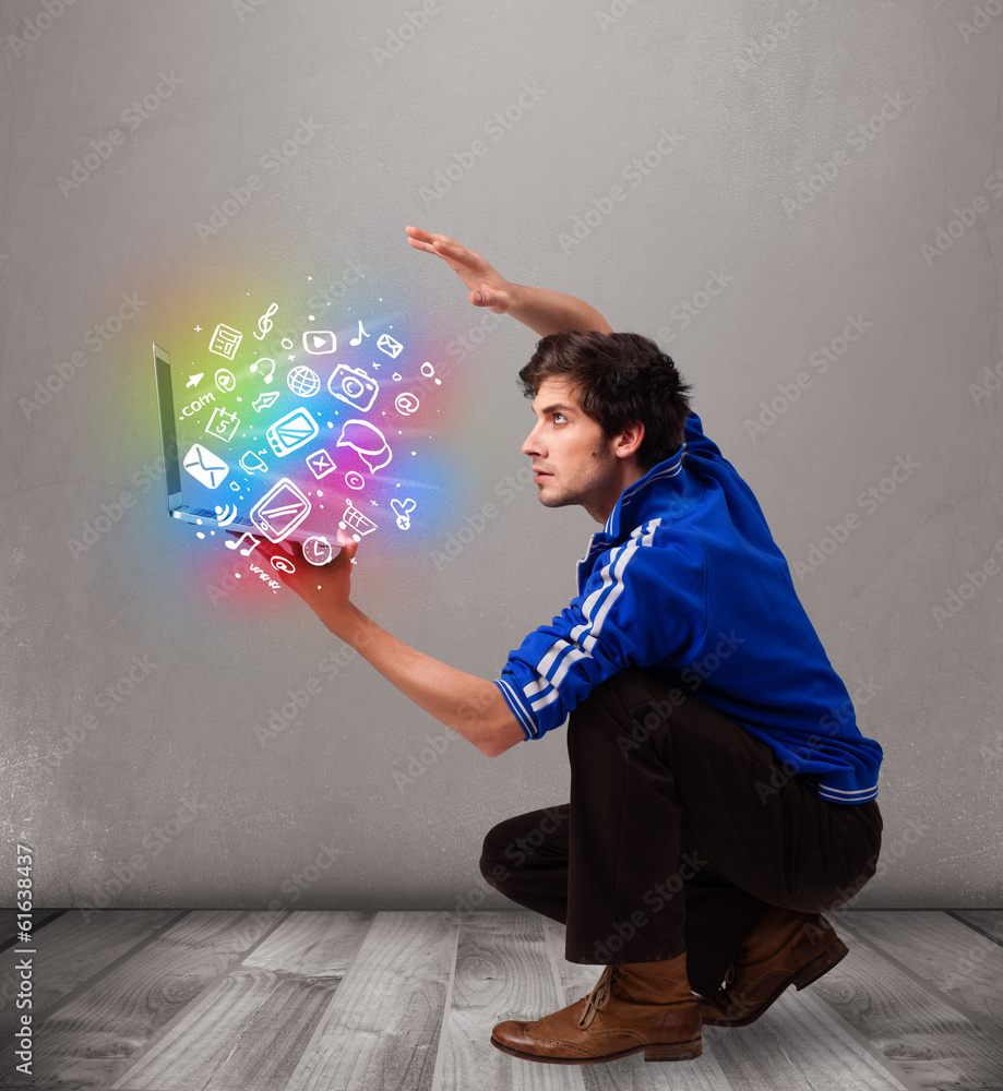 Casual man holding laptop with colorful hand drawn multimedia sy Casual man holding laptop with colorful hand drawn multimedia sy