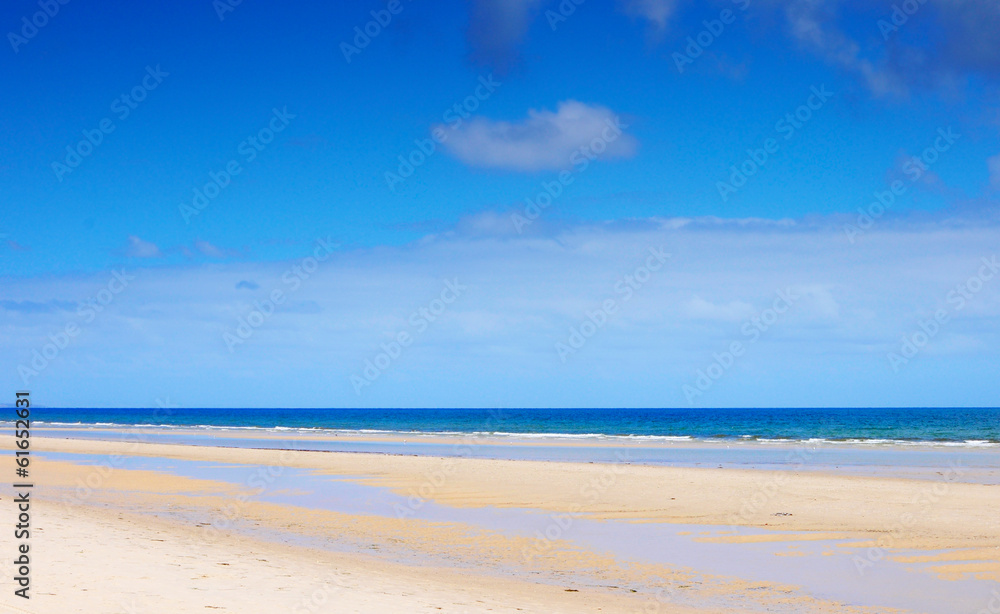 Beautiful wide open beach with blue skies in Summer.