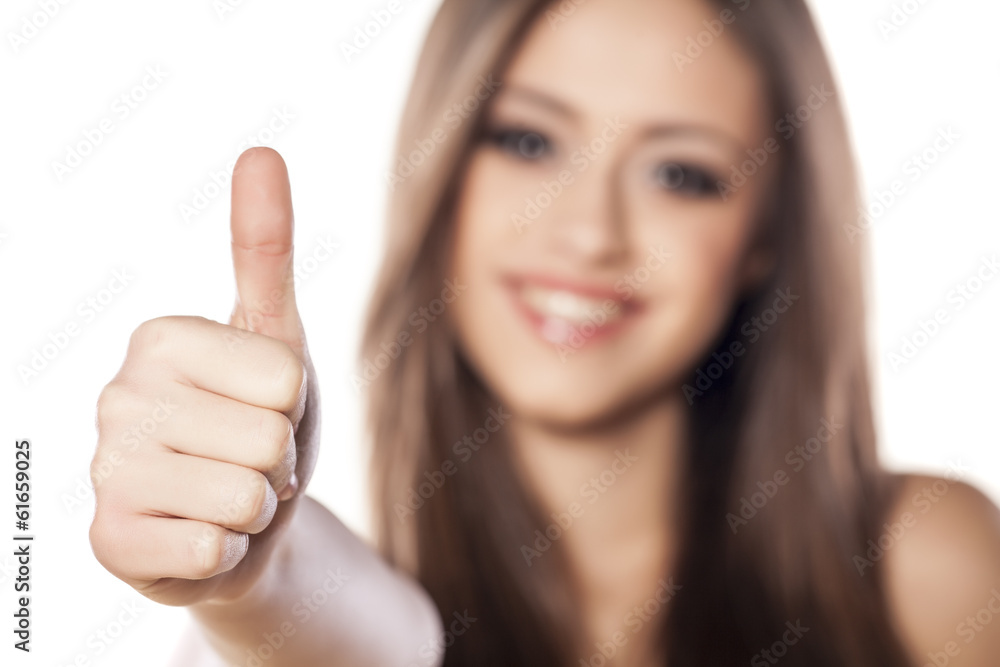 Smiling girl showing thumb up on white background Smiling girl showing thumb up on white background