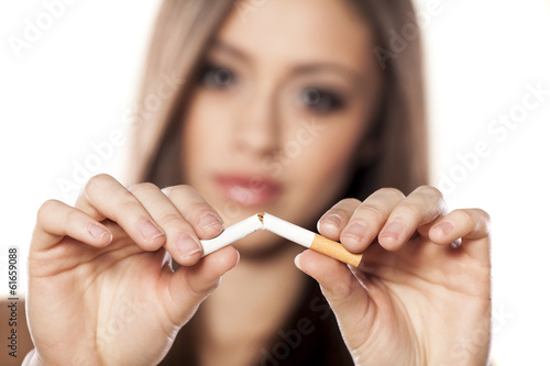 serious girl breaks a cigarette with a focus on the foreground