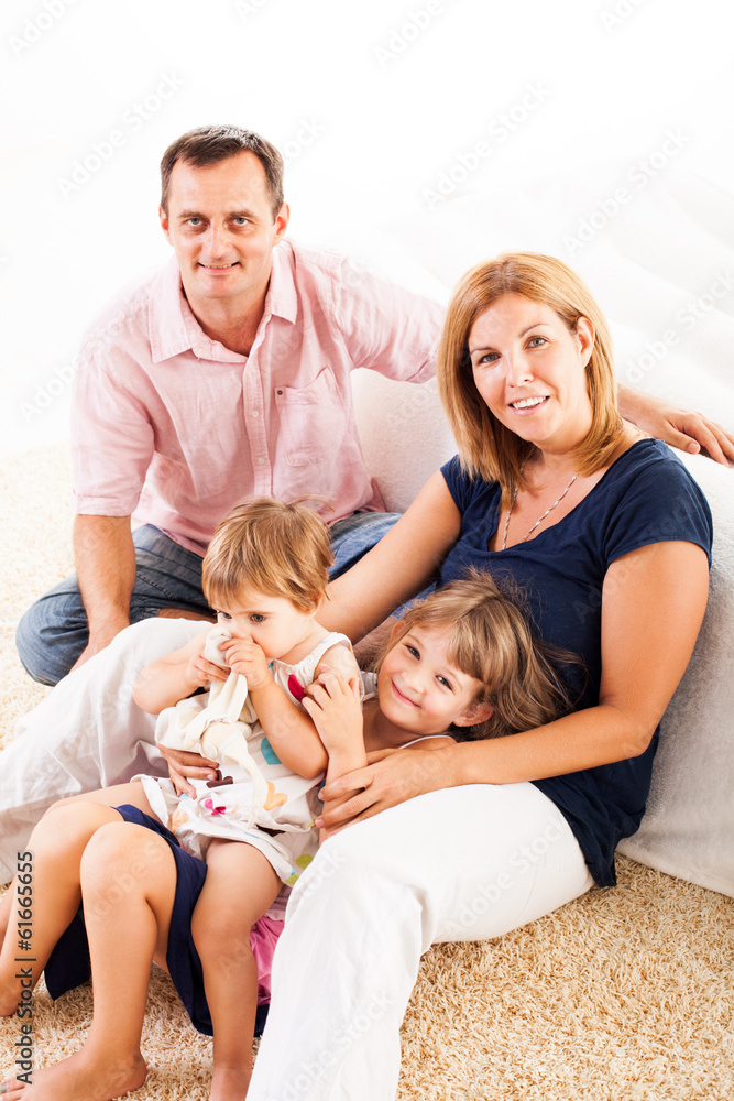 Beautiful happy family sitting on the carpet. Beautiful happy family sitting on the carpet.