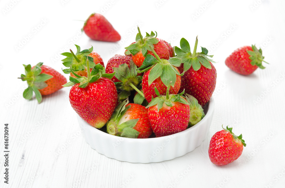 Fresh ripe strawberries in a bowl on a white table Fresh ripe strawberries in a bowl on a white table