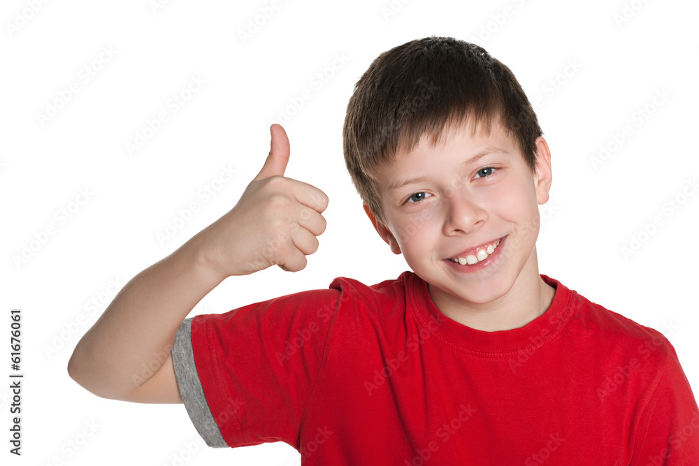 Preteen boy in the red shirt holds his thumb up Preteen boy in the red shirt holds his thumb up