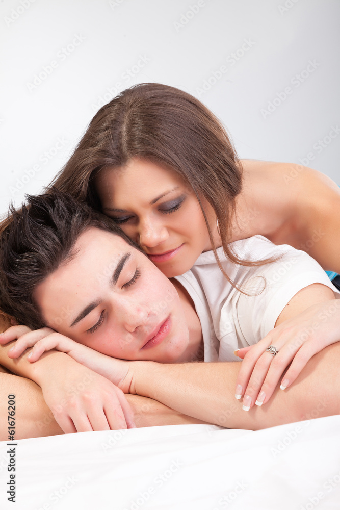 Portrait of happy young couple lying in bed and smiling Portrait of happy young couple lying in bed and smiling