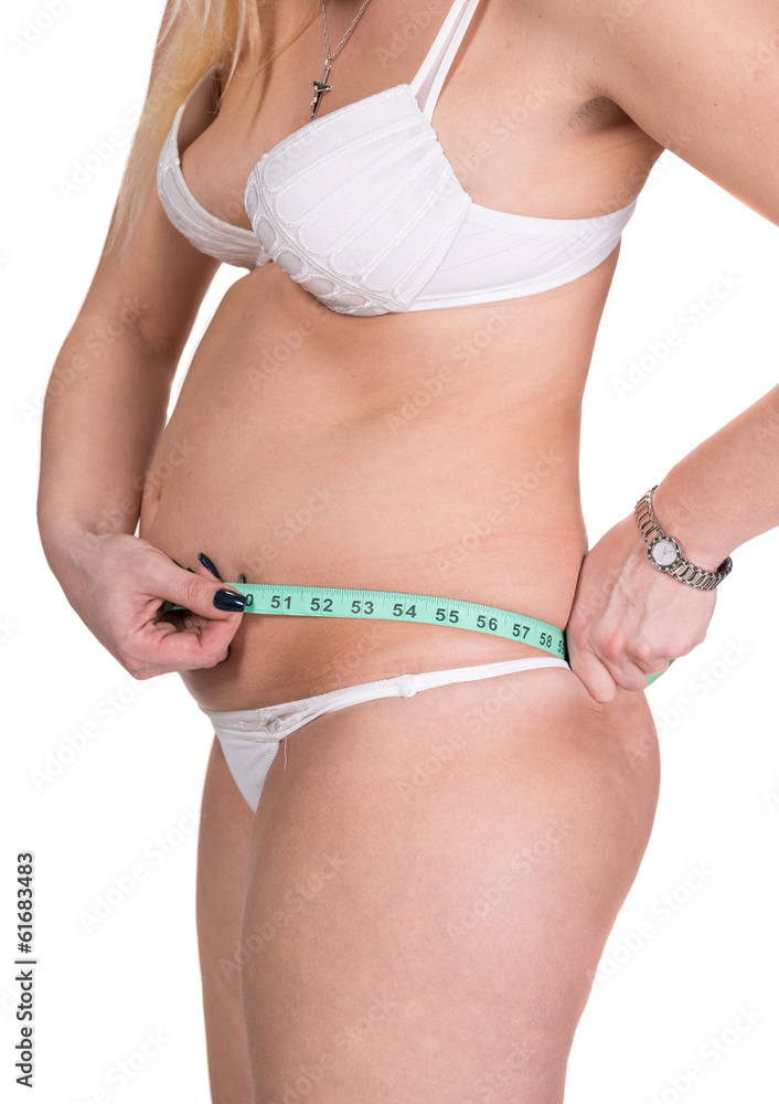 Overweight woman measuring waistline with centimete
