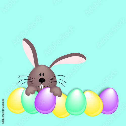 Brauner Hase hinter bunten Eiern