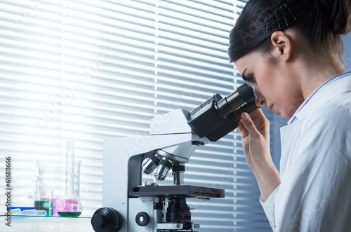 Female researcher using microscope