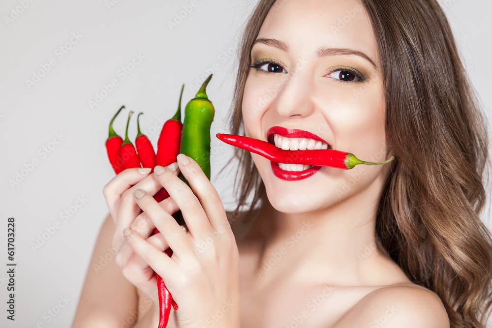 portrait of an attractive young woman holding up peppers portrait of an attractive young woman holding up peppers
