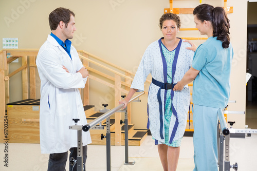 Physical Therapist With Doctor Assisting Female Patient In Walki photo