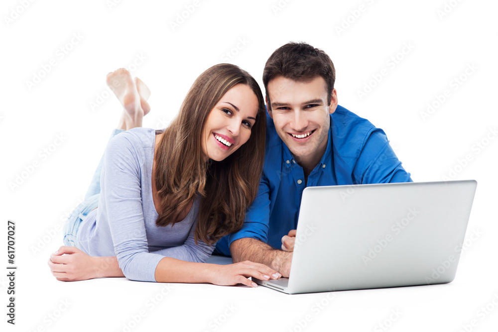 Couple lying and using laptop