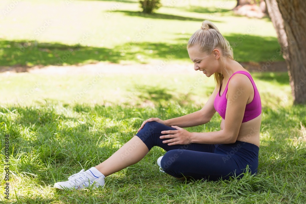 Healthy and beautiful woman in sportswear sitting in park