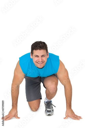 Portrait of a sporty smiling man in running stance