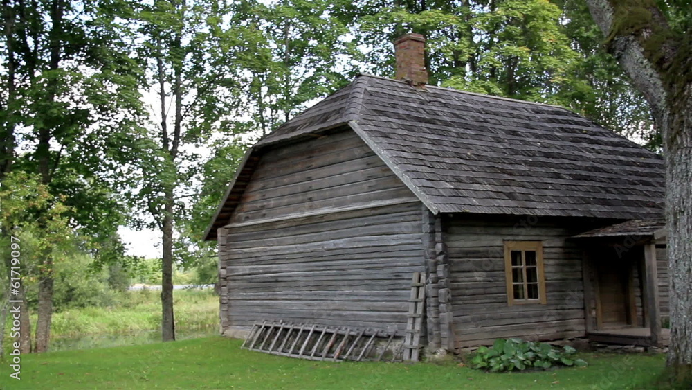 The old wooden log house made in lumbers surrounded with trees The old wooden log house made in lumbers surrounded with trees