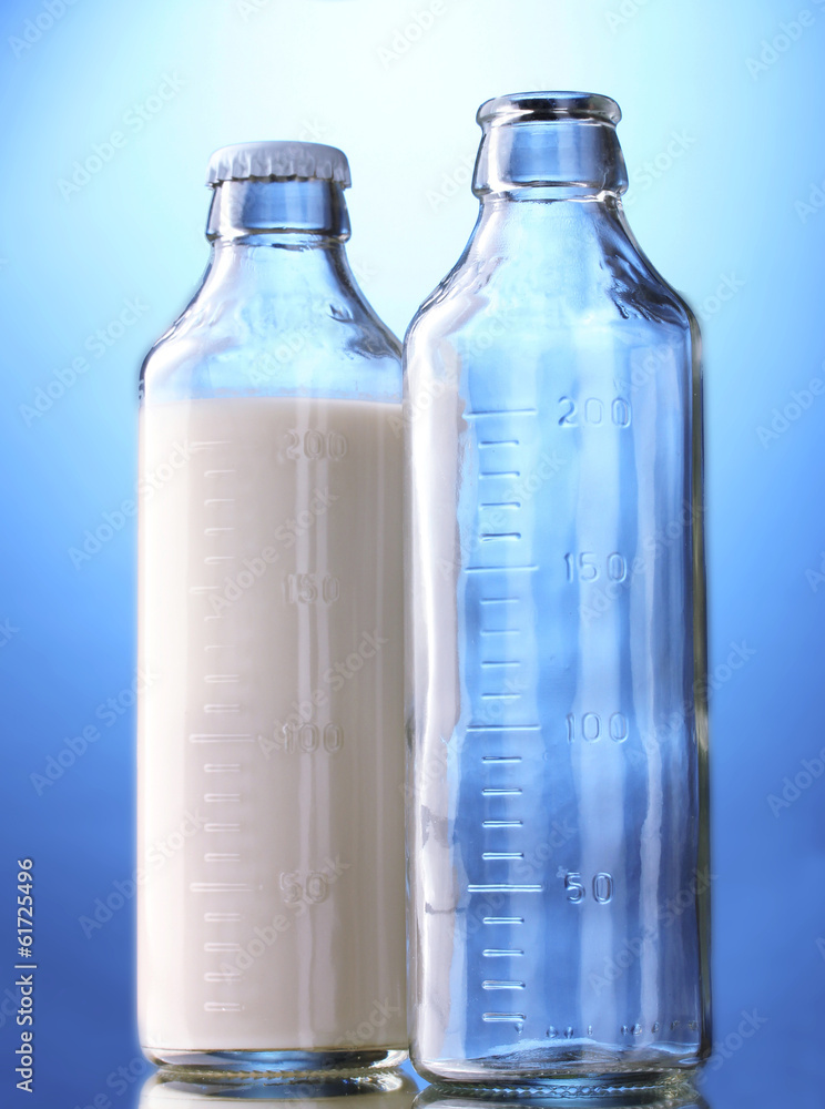 bottle of milk and empty bottle on blue background bottle of milk and empty bottle on blue background