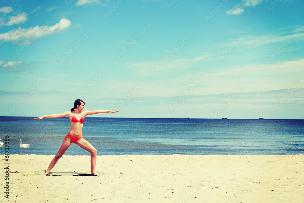 Athletic, fit young woman  is training exercises on the beach.